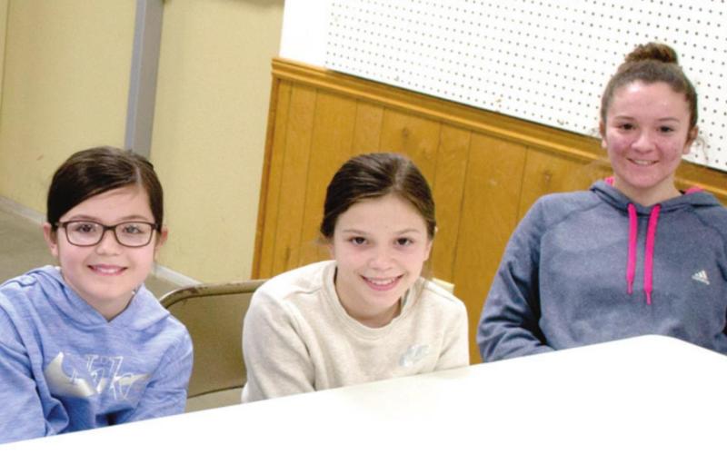 Getting their sheep and goat projects ready for the fair requires continual animal education, which brought Madison, Morgan and Anna Duling to the Sheep and Goat meeting. The three sisters were accompanied by their parents.