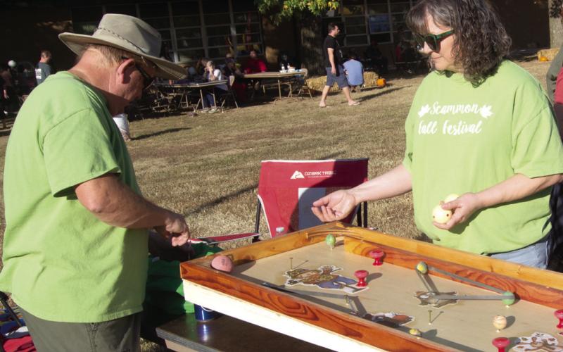 A homemade wooden pinball game was a popular game at the festival. Built by Bill Henderson the billiard balls go around hitting bumpers until they end up in one of the prize slots. Shelly Henderson hands out the prizes to the players