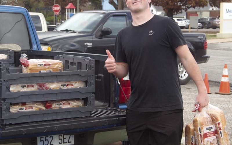 Jett Tanner was one of the Columbus High School students passing out food for the Thanksgiving boxes. Lines for the boxes were long and lined up several blocks from the pick up location. News Report photo by Shawn Churchill.