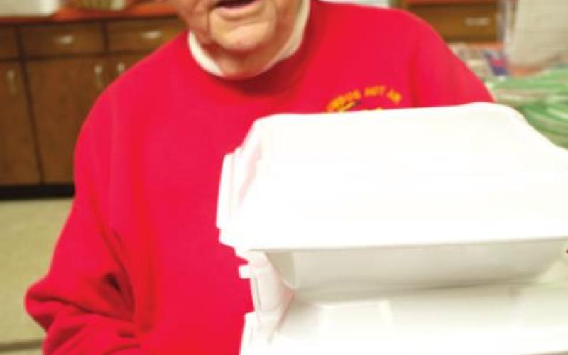 Chamber of Commerce Director Jean Pritchett carried to go meals to customers at the recent fireworks cookout.