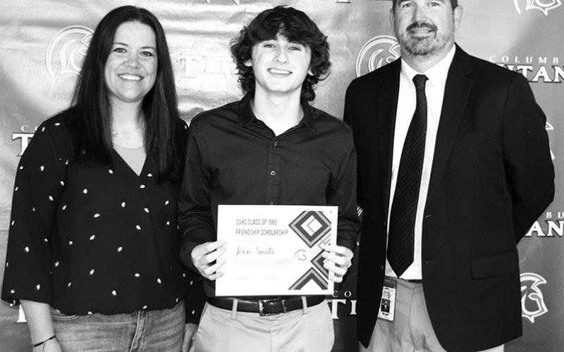 Senior John Smith received a $500 CUHS Class of 1986 Friendship Scholarship from CUHS Principal Dan Grundy and USD 493 instructor Kelly Walters during the Columbus Unified High School Senior Awards Ceremony, May 17 at the high school gymnasium.