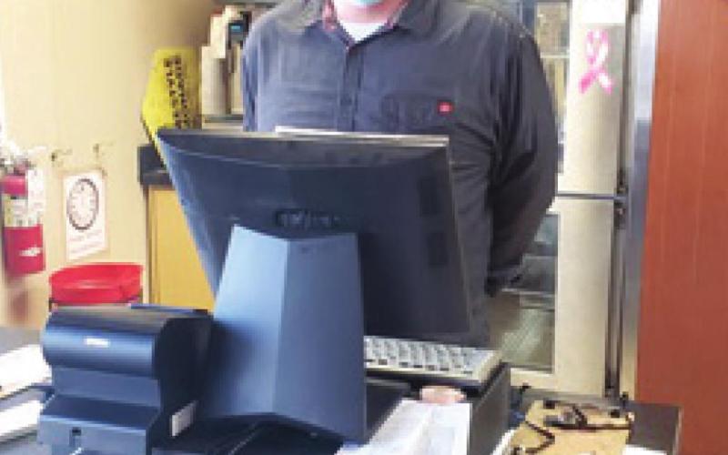 Tyson Coombes, manager at the Baxter Springs Pizza Hut, is behind the register ready to serve the community members hungry for pizza.