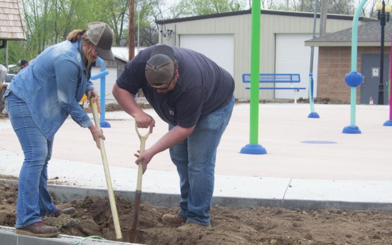 Columbus Parks and Property employees Kasie England and John Shallenburger worked to prepare the ground surrounding the H and H Splash Pad. The attraction opens to the public with an official celebration May 20. Photo by Jacob Spencer.