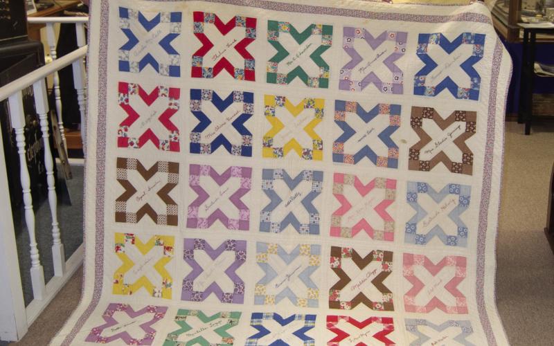 Holding the quilt donated to the museum by Annette Lopp Robertson are Doris Richardson and Carol Phelps.