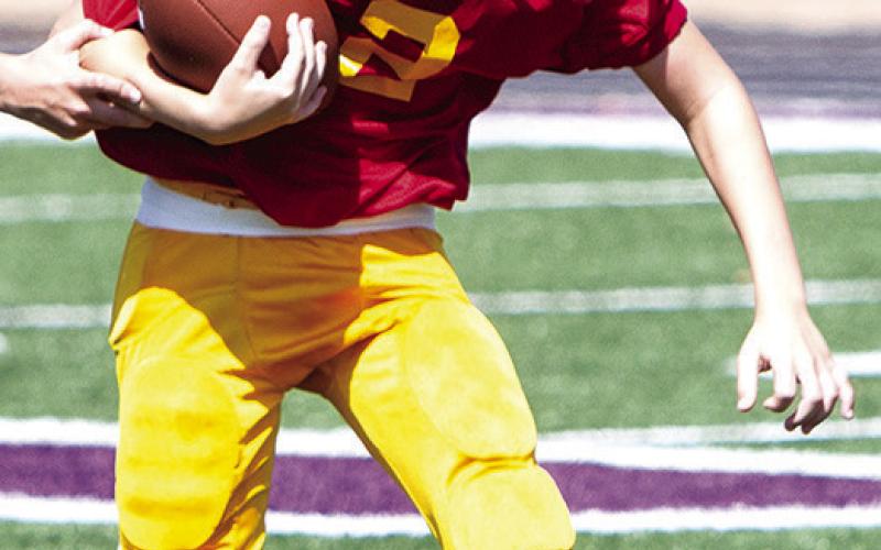Jaxon Harper carries the ball for the Columbus Fifth/ Sixth Titans in their 20-6 win over Pittsburg Woods, September 21, in Pittsburg. Photo by Kristin Sharp.