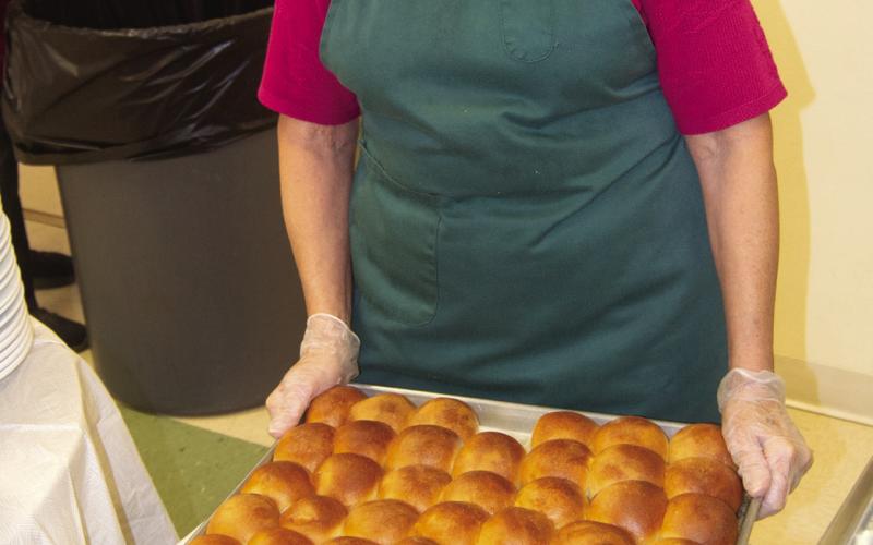 Ella Buzzard was in charge of serving the hot rolls at a recent noodle dinner hosted at St. Bridgets.