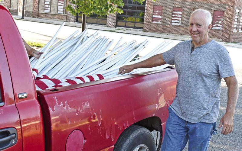 Baxter Springs Mayor Kelly Abbott was taking down the flags members of the Kiwanis Club had put up for Memorial Day. The club places flags around town for all patriotic celebrations.
