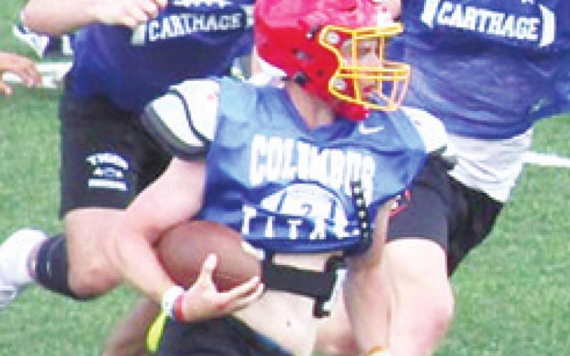 Senior Titan Quarterback, Jaxson Haraughty, is chased by members of the Carthage Mo. High School defense during drills at the Pittsburg State University Team Camp, Saturday through Monday at Carnie Smith Stadium. Courtesy Photo.