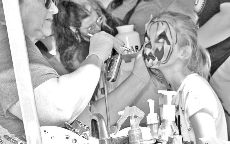 Who doesn’t love getting their face painted? This youngster was becoming a Jack-O-Lantern during the annual Columbus Day Festival. Photo by Neva Hiatt.