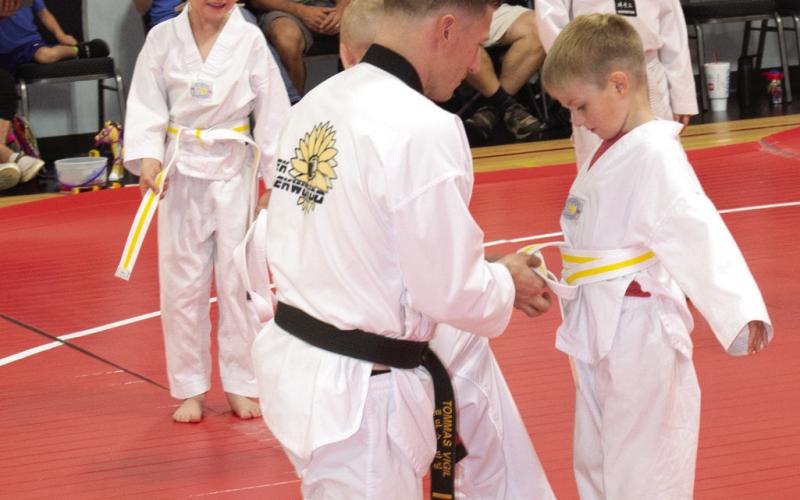 Above, student Luke Rowton receives his yellow stripe belt from Master Vigil during the ceremony.