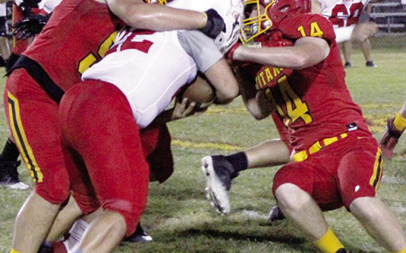 Freshman Kash Smith, the Titans leading tackler, and senior, Brandon Stice, stop Lion Running Back, Sam Weaver, junior, short of the marker creating a turnover on downs late in the Titans win over Baxter Springs, 62-30, Friday at Titan Stadium.