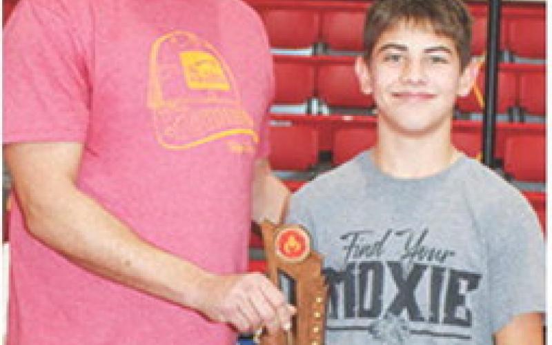 Blaze Bowman receives his Outstanding Wrestler Trophy from Clint Saporito during award presentations at the Sixth Annual Ken Jones Classic Wrestling Tournament hosted by the Columbus Wrestling Club, December 22, at the CUHS Gymnasium. Blaze was also the winner of the 14U, 105-110 pound weight class in the tournament.