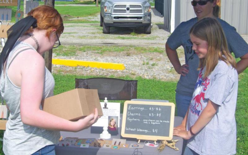 The Columbus farmers market has officially opened to the public for the 2022 season. Molly Sauerwein checks out a booth operated by Christina Martin and Kate Martin during the opening day of the market, May 19. Photo by Jacob Spencer.