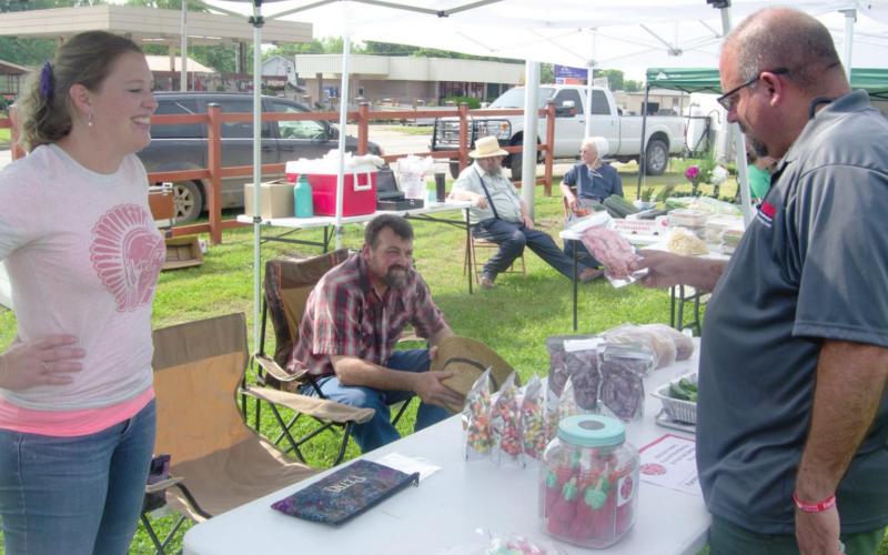 Several community members returned to make the most of the opening day for the Columbus farmers market. Michael Boesker checks out a table of sweet treats from Mashea Shultz’s booth, May 19. Photo by Jacob Spencer.
