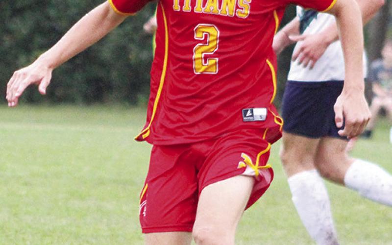 Titan Senior, Korbyn Newberry, controls the ball during the varsity soccer match against Liberty Home School, Monday, at the Central School Soccer Pitch.