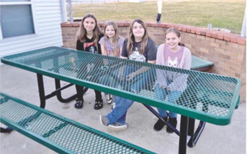 Area Girl Scouts Alyssa Montierth, Lilly Linam, Raygen Spoonemore and Eleanor Holt sit at the new tables installed at the Girl Scout House in Columbus. The tables were made possible by a grant from the SEK Community Foundation. Courtesy photo.