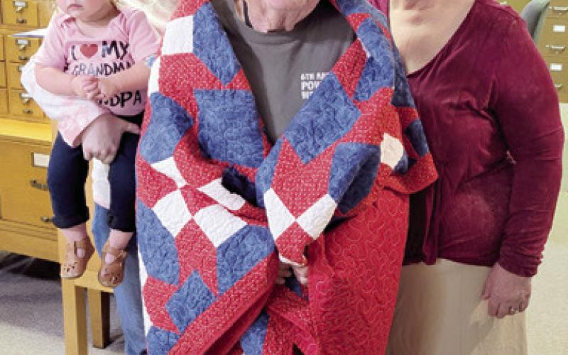 The presentation of a Quilt of Valor to Columbus native Homer Wayne Dobkins at the Columbus Genealogical Society meeting last week. Dobkins, a Navy veteran is the vice-president of the genealogical society. Attending the presentation was Wayne’s wife Juanita his granddaughter Aspen Miller and greatgranddaughter Atlas Peters.
