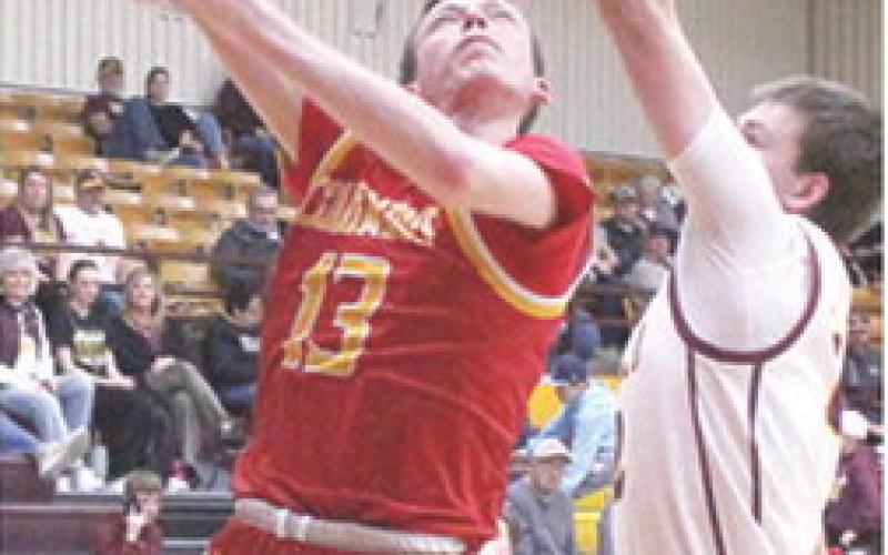 Titan Junior, Carter Woodcock, goes up for two of his team-high, 18 points in the 43-55 loss in Girard, Tuesday. Junior, Ben Cullen defends for the Trojans.