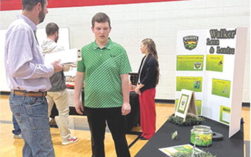 The annual Youth Entrepreneurship fair was held yesterday at Baxter Springs High School. Brooks Walker discussed his landscaping business with judge Mike Evans. Courtesy photo.
