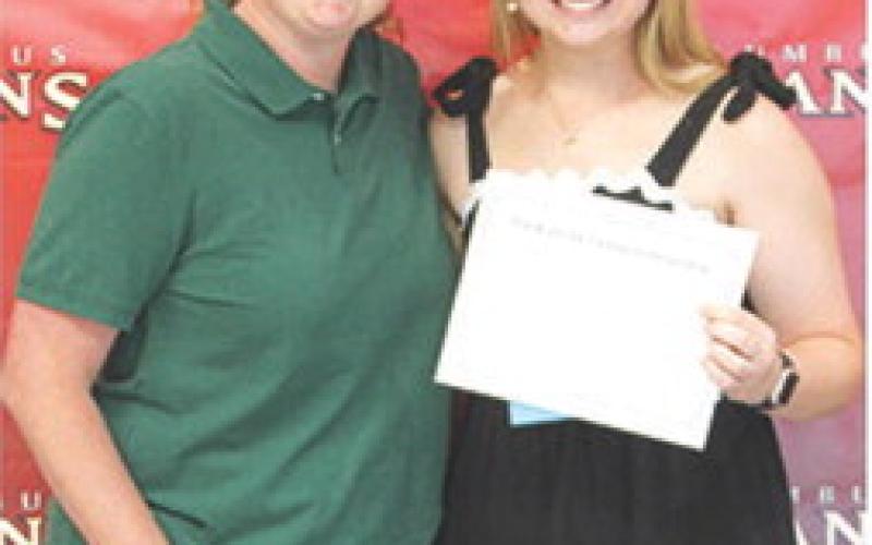 CUHS Assistant Music Director, Christine Lovell, presented the Blanche Combs Scholarship for $100 to Trinity Green at the May 15 Senior Assembly in the Columbus Unified High School Gymnasium.