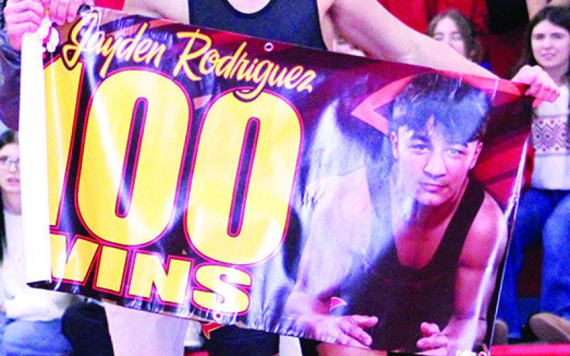 Titan Senior, Jayden Rodriguez received a banner for his 100th career win from Titan Head Coach Marcus Bowman following his win by fall over 2025 Arkansas State runner-up, Max Eldridge, Shiloh Christian School, Thursday, on his home mats at the CUHS Gymnasium. Complete dual coverage is on page 6 of today’s News-Report.