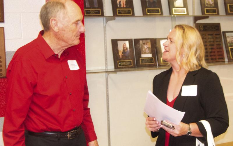 Baxter Springs coach Don Karnes talks with Hall of Fame inductee Pam Brewer-Hunt at the ceremony on Saturday night. Karnes described her as having all the qualities of a basketball point guard.