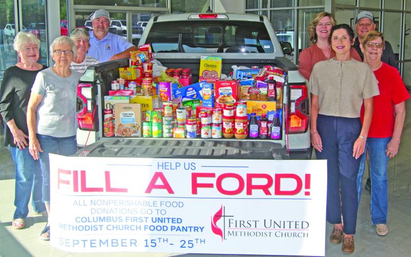 The Ford pick-up truck loaded with 840 pounds of groceries, collected by Mike Carpino Ford was delivered to the Columbus United Methodist Church food pantry after two weeks of collection. Those with the truck include on the left side Nancy Evans, Sharon Draeger, Sue McKenzie and Robbie Carpino. On the right-side, Jamie Huston, Jay Wary, Hannah Carpino and Anita Davolt.