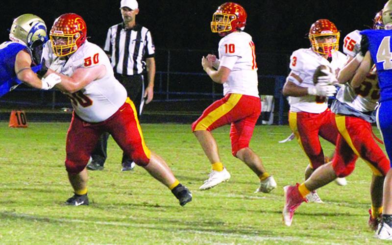 Senior Quarterback, Jack Vilela handed off to junior, Jayden Rodriguez, while seniors, Carter Henry and Jonah Smith make a hole in the line. The Titans took the CNC League win in a 36-0 shutout over the Rams in Riverton, Friday.