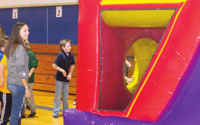 A line forms inside of one of Riverton High School’s gymnasiums as students prepare to race down a blow up obstacle course. Students had a lane of obstacles to climb over in order to beat their opponents in the popular attraction. Photo by Jacob Spencer.
