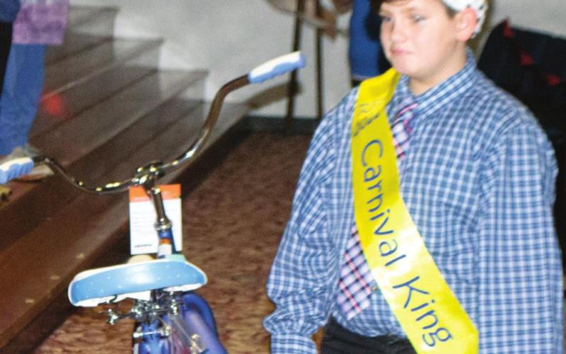 Riverton School District’s PTO Carnival King Colton Bebee claims his prize after a coronation ceremony concluded. Bebee and three other peers were all crowned and given sashes for their high ticket sales. Additionally, they all earned bicycles as prizes. Photo by Jacob Spencer