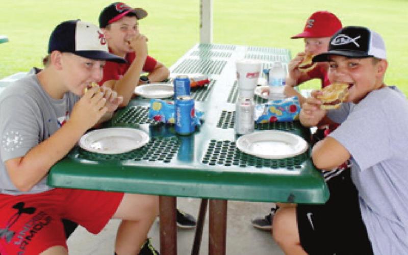 Participating in a cornhole tournament makes players hungry. Baxter Springs American Legion Auxiliary members made sure Cole Parrish, Riley Daniel, Logan Abbott and Grady Roller didn’t leave with an empty stomach. The tournament, sponsored by the American Legion Auxiliary was held Saturday in Kiwanis Park in Baxter Springs. Photo by Dee Riley.