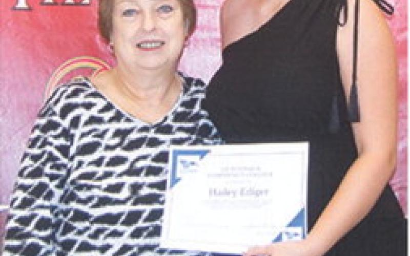Hailey Ediger received two scholarships from Hutchinson Community College to play softball during the Columbus Unified High School Senior Assembly, May 16, at the CUHS Gymnasium. She received $4,052 books, tuition, and fees scholarship and $2,000 housing scholarship from presenter, Karen Langerot, USD 493 Instructor.