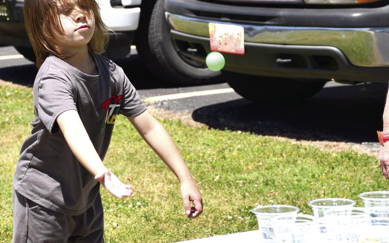 Aiming for one of the small cups, Malco Wilkins tossed his ping pong ball in an effort to win a prize at the Park School carnival held before school let out for the summer.