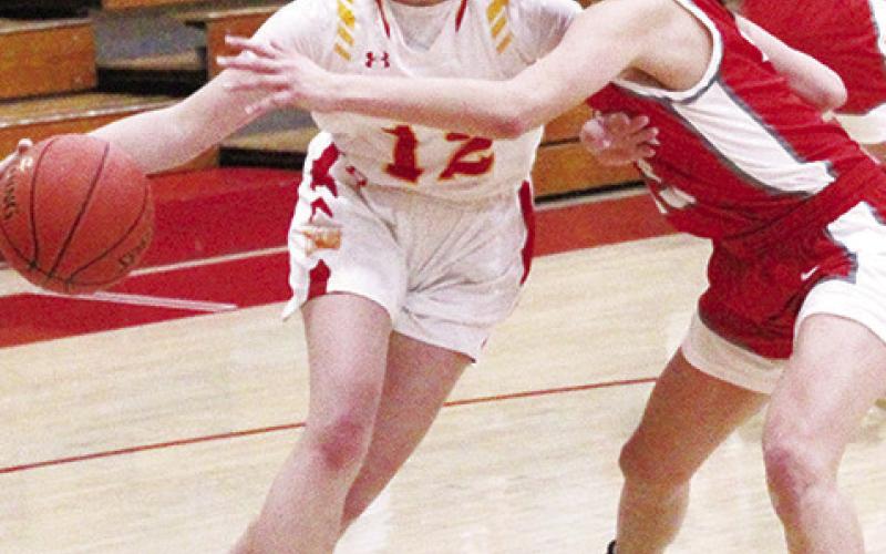Lady Titan Junior, Ava Harman, drives around her Liberal, Mo. opponent on the way to two points in the 54-50 Columbus win, Thursday, at the Titan Gym.