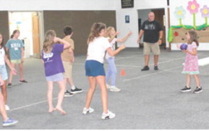 Several youngsters, as well as adults, attended Bible School at Center Christian Church recently. Above Curt Zahm and below David Eddington lead activities.