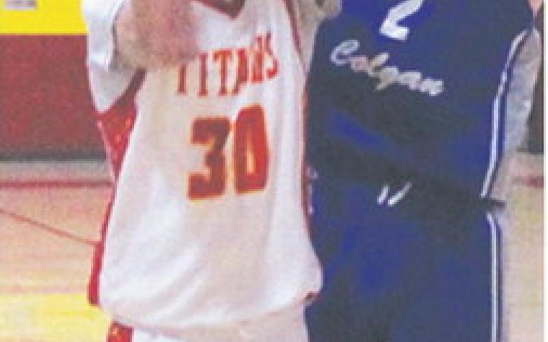 Drake Laurance, Titan Sophomore, shoots for two in the home opener against St. Mary’s-Colgan, Friday, at the CUHS Gym. Colgan Junior, Brady Crossland, defends the shot in the Panther win, 66-30.