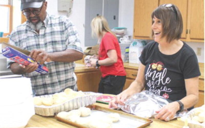 Bill Jones and Susan Shultz were among the volunteers preparing the meal for the Community Christmas dinner Saturday.