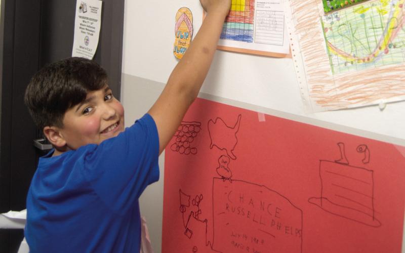 Chance Briggs points to his artwork following Compass Academy Graduation held Friday at the Columbus High School Auditorium.
