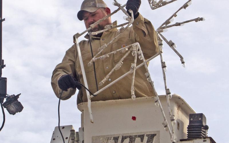 City workers Justin Rogers (pictured), Jared Kite and Kasie England took down the Christmas lights after the holidays. News Report photo by Shawn Churchill.