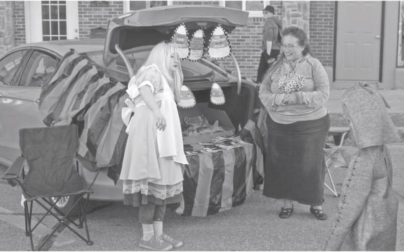 Many of the booths at the annual Halloween trunk or treat event decorated with creative costumes and banners. Alice and candy corn were part of this booth.