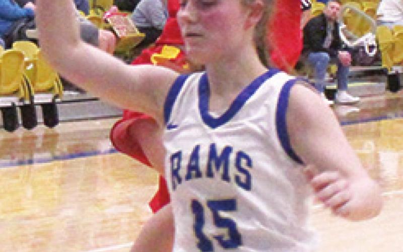 Lady Titan Senior, Lily Mooney, goes up for a lay up over Lady Ram Junior, Morgan Compton following a steal and full court drive during the Columbus 31-28 win at Riverton, Friday. Lily led all scoring with 14 points on the night.