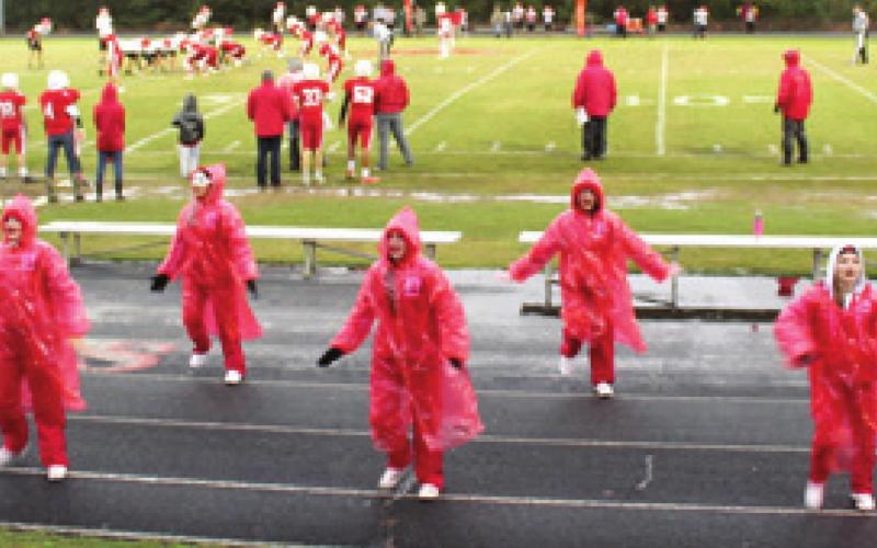 Kelsey Brown, Andi Johnson, Bella Fugate, Laylah Trejo, Lilly Weston, and Keely Barngrover, cheer on their Lions in the pouring rain during the last game of the season. Photo by Dee Riley.