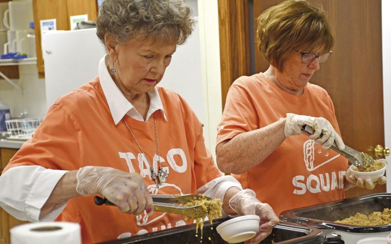 Jane Ann Turner and Bobbi Martin filled the dishes with chicken for the chicken taco fundraiser. The group is working toward the purchase of an inhouse 3D mammography machine.