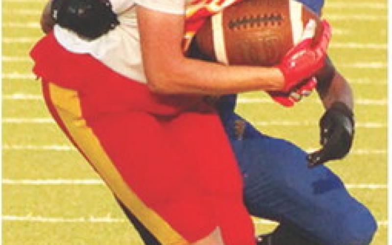 Gavin DePratt, Columbus Titan Senior, tries to escape the clutches of the Parsons Defender after making a catch during the four-team, Jamboree Scrimmage, Friday, at Girard. Parsons, Pittsburg, and Columbus varsity and junior varsity teams met their host team, Girard, at Frank Jameson Field for the scrimmage that has each team facing off in a series of plays before switching opponents throughout the event.