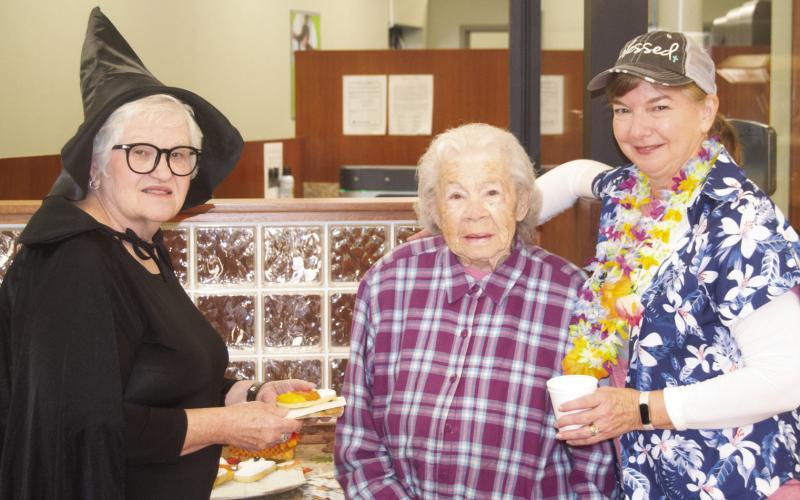 The staff and customers were enjoying the refreshing apple cider and cookies Friday during the annual Commerce Bank Customer Appreciation Day. Patty Dunnic was dressed as a witch, bank customer Eva Forkner was receiving refreshments from Janette Crain dressed for a Hawaiian trip. News-Report photo by Shawn Churchill.