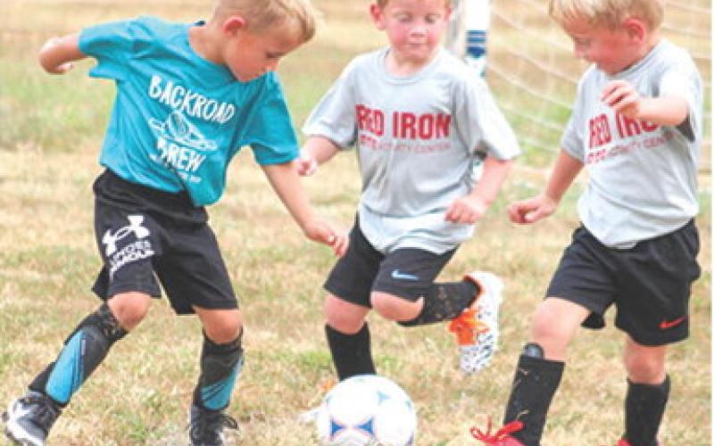 Luca Dainty, Trip Irwin and Reid Irwin are ready to attack the ball during their age three and four soccer game, Saturday, at Eddington Park in Columbus. The Recreation Soccer League has five weeks remaining in their season.