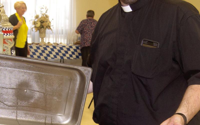 After the bierocks came from the oven Fr. Chris Martin displays his handiwork. A large crowd attended the Octoberfest dinner at St. Bridgets.