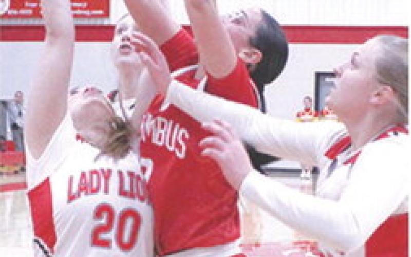 The shot for the record books, Katy Mooney, Lady Titan Senior, gets a put-back on her third attempt over senior, Ashlynn Hall, and surround by her opponents in the 58-21 win over the Lady Lions in Baxter Springs, Monday night. Katy’s basket accounted for her 999th and 1,000th career points, adding her name to the Lady Titan Basketball record book.