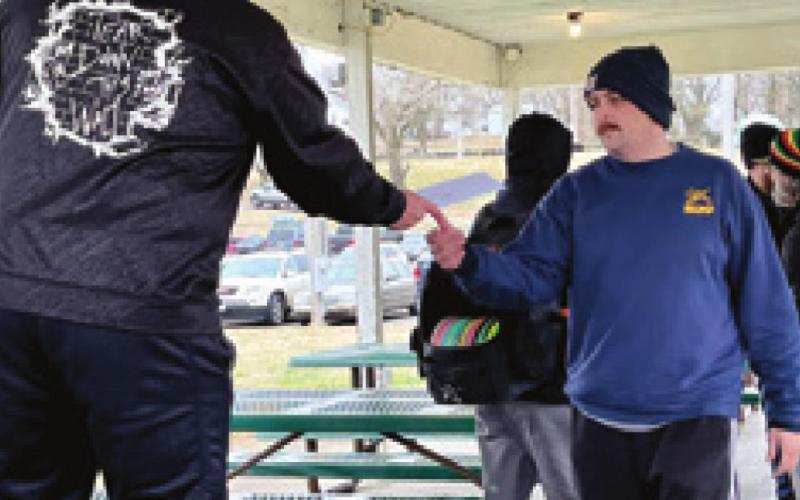 Firefighters from Baxter Springs, Columbus, Joplin, Mo. and Kansas City, Mo., participated in the fundraising tournament for the family of Malachi Brown. Michael Dulle accepts prize check from Baxter Disc Club president Charles Rector. Dulle is a firefighter from Kansas City, Mo. Photo by Dee Riley.