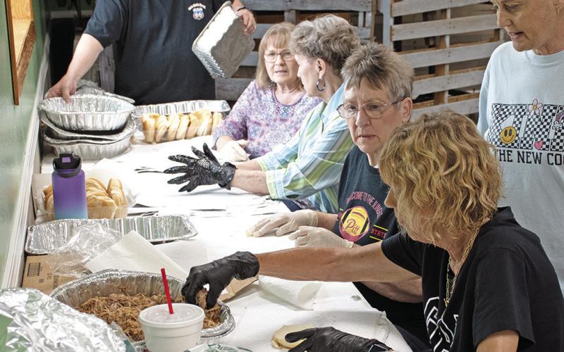 Pulled Pork Sandwiches were on the menu for the Ed Semonick benefit dinner last Wednesday. Volunteers Rick Walden, Karen Karsten, Jane Ann Turner, Janice Maxton and Marilyn Epler prepared and wrapped more than 400 sandwiches for benefit. Also pictured, Michelle Mosler worked to move finished sandwiches to prepared sack lunches.
